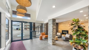 A modern lobby with a reception desk, seating area, and a large potted plant. - Glen Lyon Inn & Suites (Port Hardy)