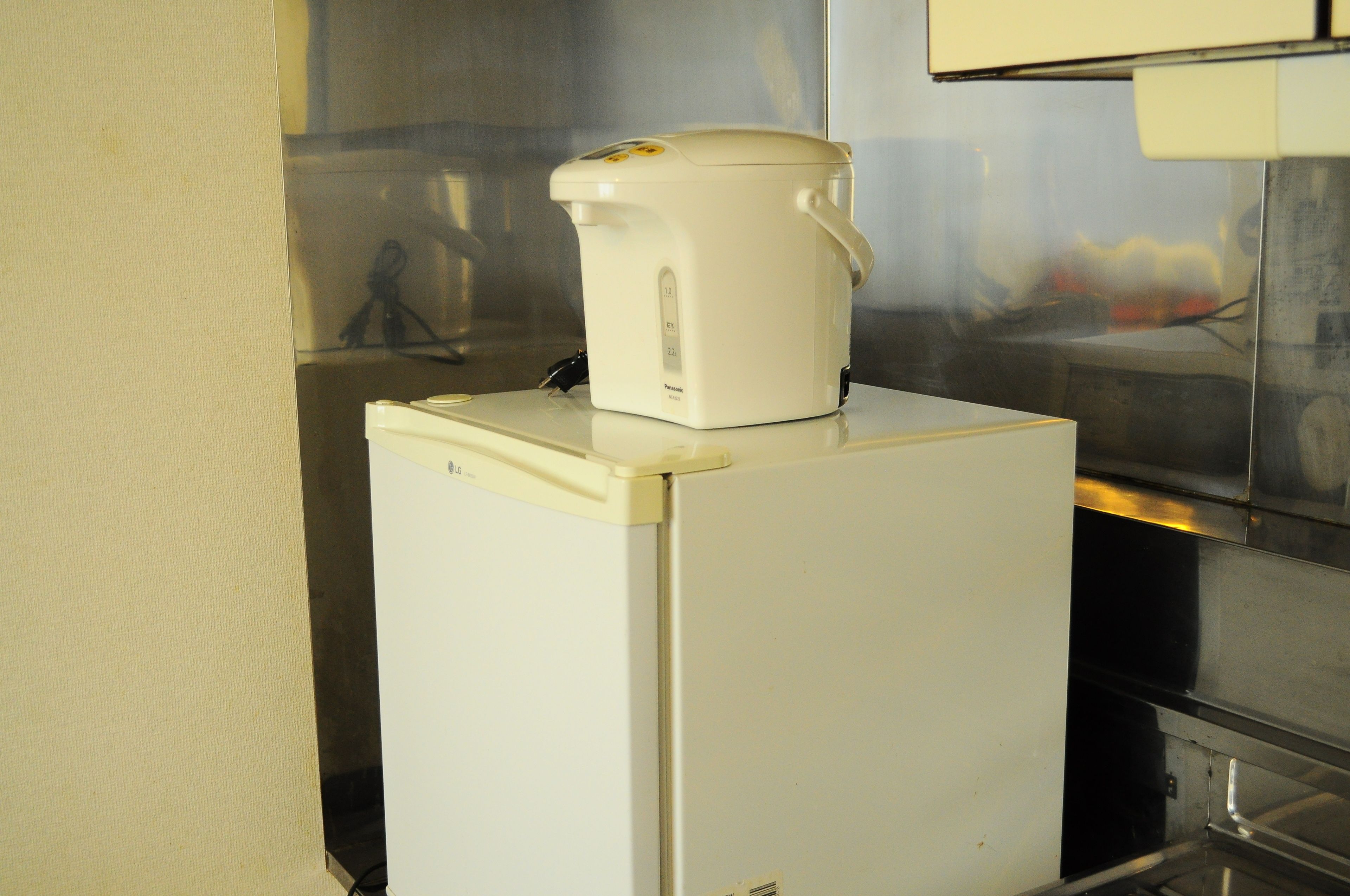 A white refrigerator with a white coffee maker on top.