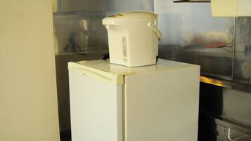 A white refrigerator with a white coffee maker on top.