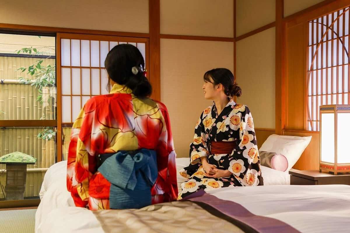 A traditional Japanese room with tatami flooring, a low wooden bed, and shoji screens.