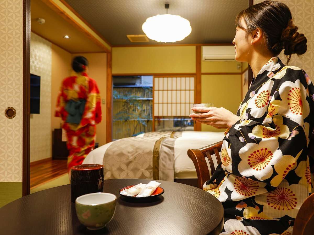 Ein traditioneller japanischer Raum mit Tatami-Böden, einem niedrigen Tisch mit Teeservice und einem Futon.