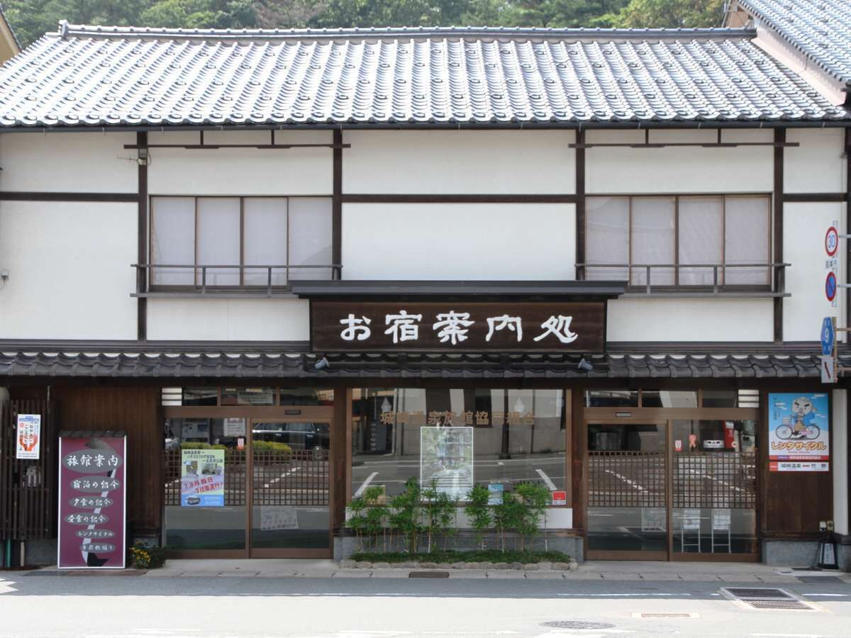 Un bâtiment japonais traditionnel, doté d’un toit recouvert de tuiles et d’une enseigne.