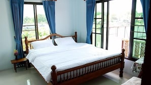 Une chambre à coucher avec un lit en bois, une petite table de chevet et une chaise.