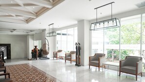 A spacious lobby with a patterned rug, modern chairs, and a hanging light fixture. - 1O1 URBAN Jakarta Glodok - Kota Tua (Jakarta)