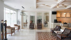 A spacious living area with a large window, a dining area, and a kitchen. - 1O1 URBAN Jakarta Glodok - Kota Tua (Jakarta)
