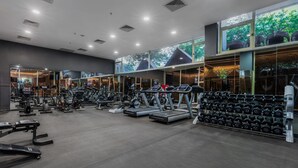 Un gimnasio con cintas de correr, mancuernas y máquinas de pesas.
