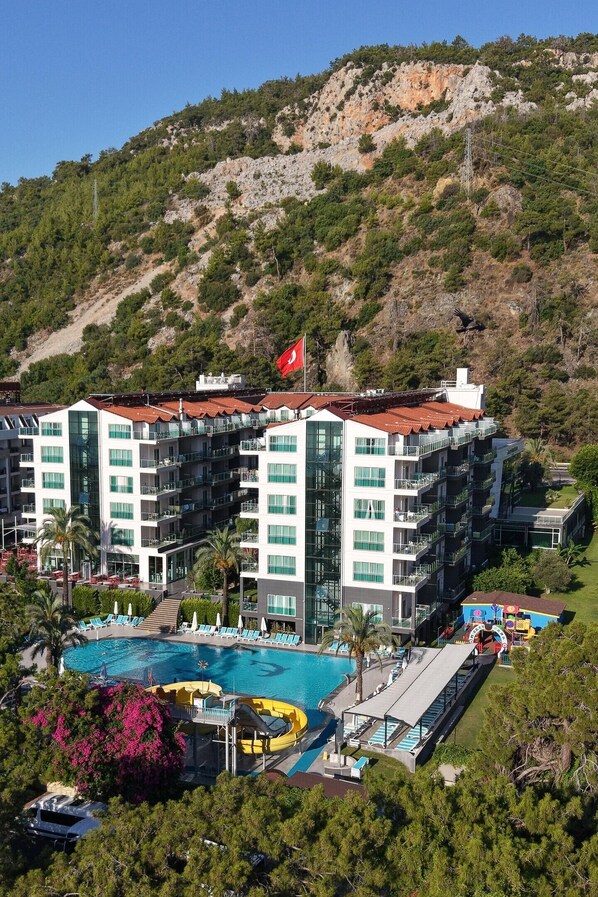 Un hôtel à plusieurs étages, doté d’une piscine et arborant un drapeau.
