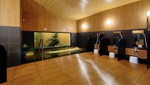 A modern bathroom with wooden paneling, a glass partition, and multiple sinks.