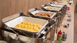 A buffet line with various food items and condiments.