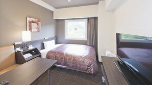 Habitación de hotel con cama, escritorio, televisor, ventana con cortinas y una obra de arte colgada en la pared.