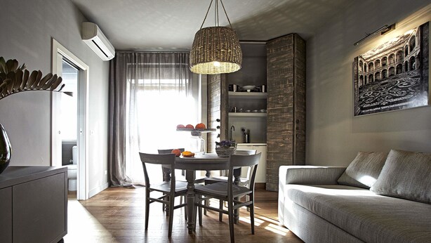 Una sala de estar moderna con comedor, un sofá y una mesa de comedor con sillas.