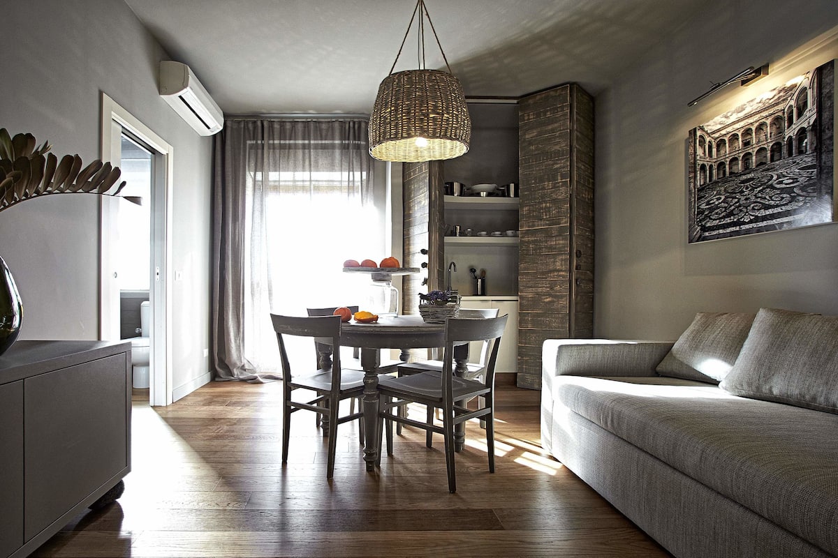 Una sala de estar moderna con comedor, un sofá y una mesa de comedor con sillas.