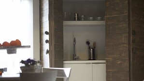 Una cocina moderna con comedor, que incluye un armario blanco, una lámpara colgante y una mesa de comedor de madera con sillas.