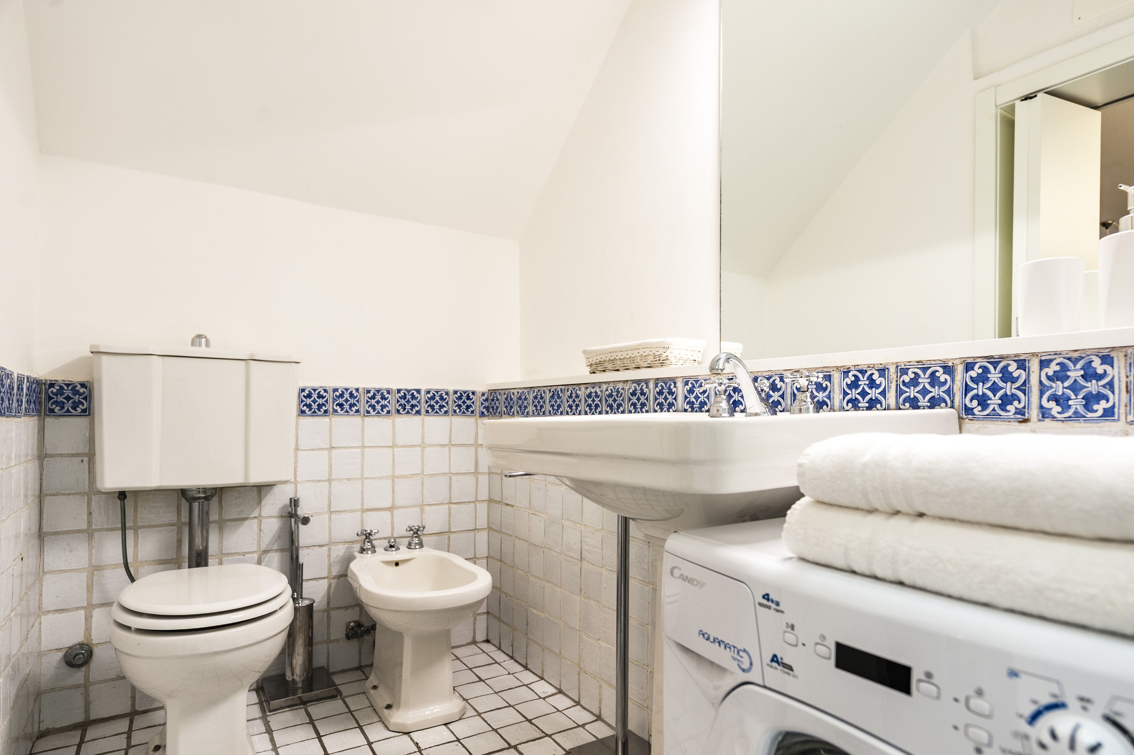 Ein Badezimmer mit Toilette, Bidet, Waschbecken und Waschmaschine.
