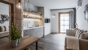 Una cocina moderna con encimera de madera, horno empotrado y una lámpara colgante.