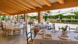 A covered outdoor dining area with tables set for a meal, surrounded by greenery and umbrellas. - Poggiovalle Tenuta Italiana (Fabro)