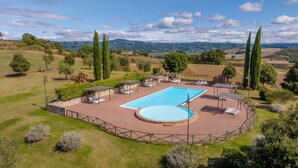 A pool area with a rectangular pool, sun loungers, and a wooden play structure. - Poggiovalle Tenuta Italiana (Fabro)