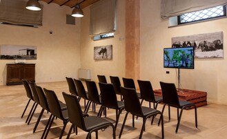 A conference room with rows of chairs, a television screen, and artwork on the walls.