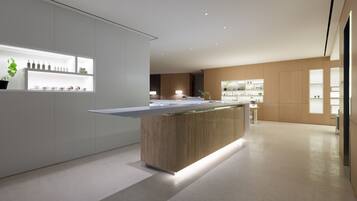 Una cocina moderna con una isla central, estantes empotrados e iluminación empotrada.