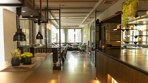 A modern hotel lobby with a long reception desk, seating area, and large windows allowing natural light. - Parkhotel Schmid (Adelsried)