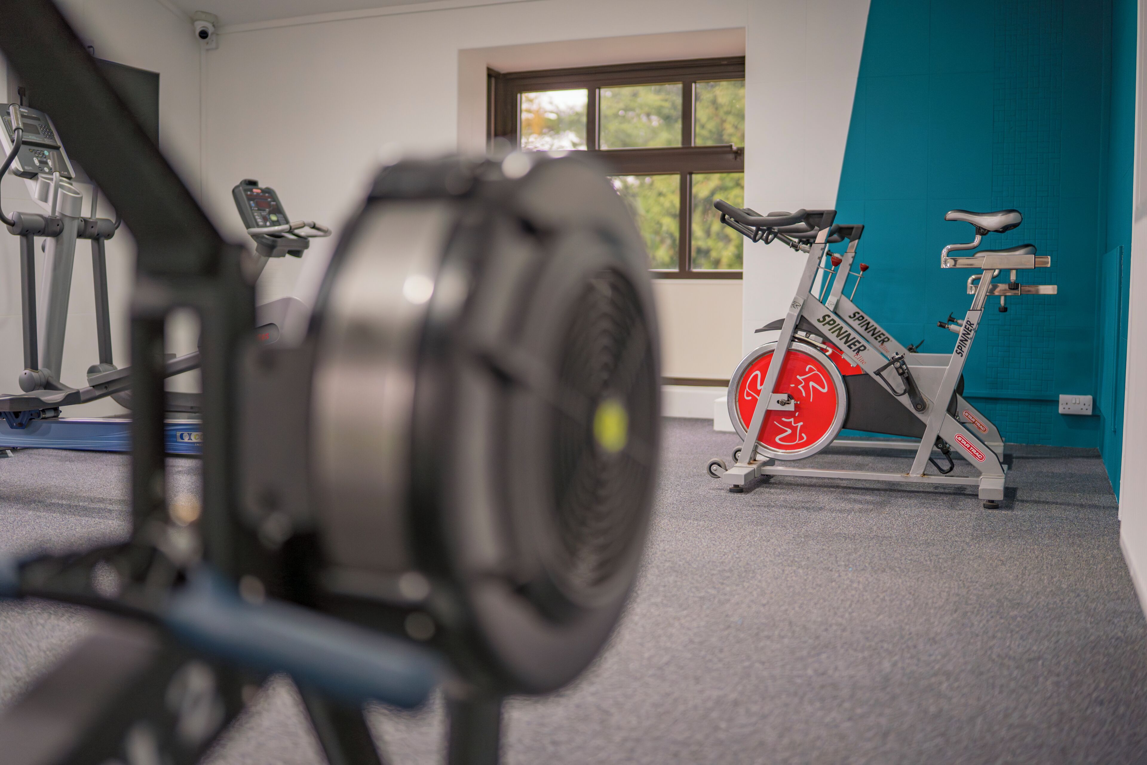A gym with stationary bikes, a treadmill, and exercise equipment.