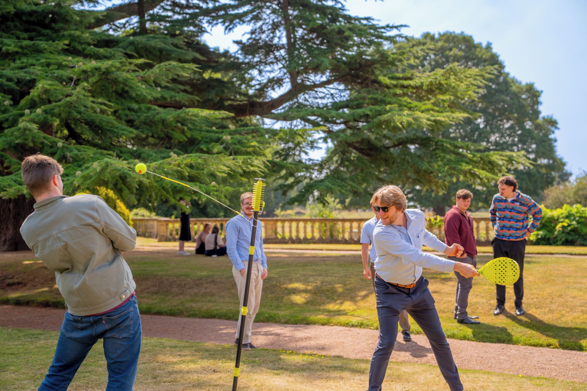 A group of people playing a game outdoors with a net and a ball.