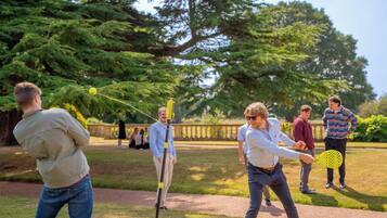 A group of people playing a game outdoors with a net and a ball.
