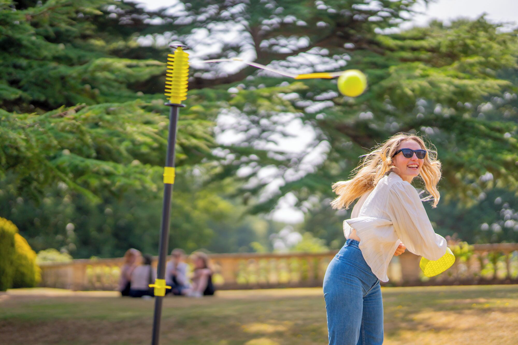 En person som leker med en gul frisbee i en park.