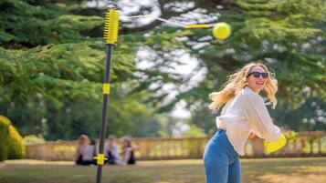 En person som leker med en gul frisbee i en park.