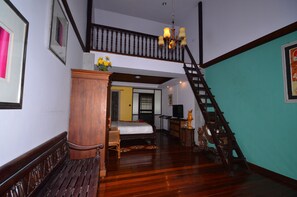 A room with a wooden staircase, a bed, a desk, and a television. - Tony's Place Beds and Breakfast (Ayutthaya)
