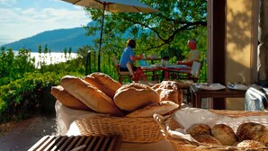A basket of bread on a table with a view of a lake and mountains in the background. - Dionysos Hotel (Marmaris)