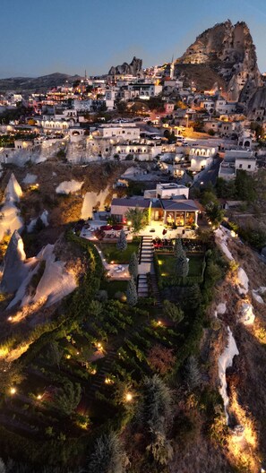Une ville construite sur une colline, dotée d’une architecture traditionnelle, d’une mosquée imposante et d’un quartier résidentiel bien éclairé, agrémenté d’un jardin.