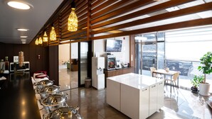 Une cuisine moderne dotée d’appareils électroménagers en acier inoxydable, d’un îlot central et d’un coin repas offrant une vue sur la ville.