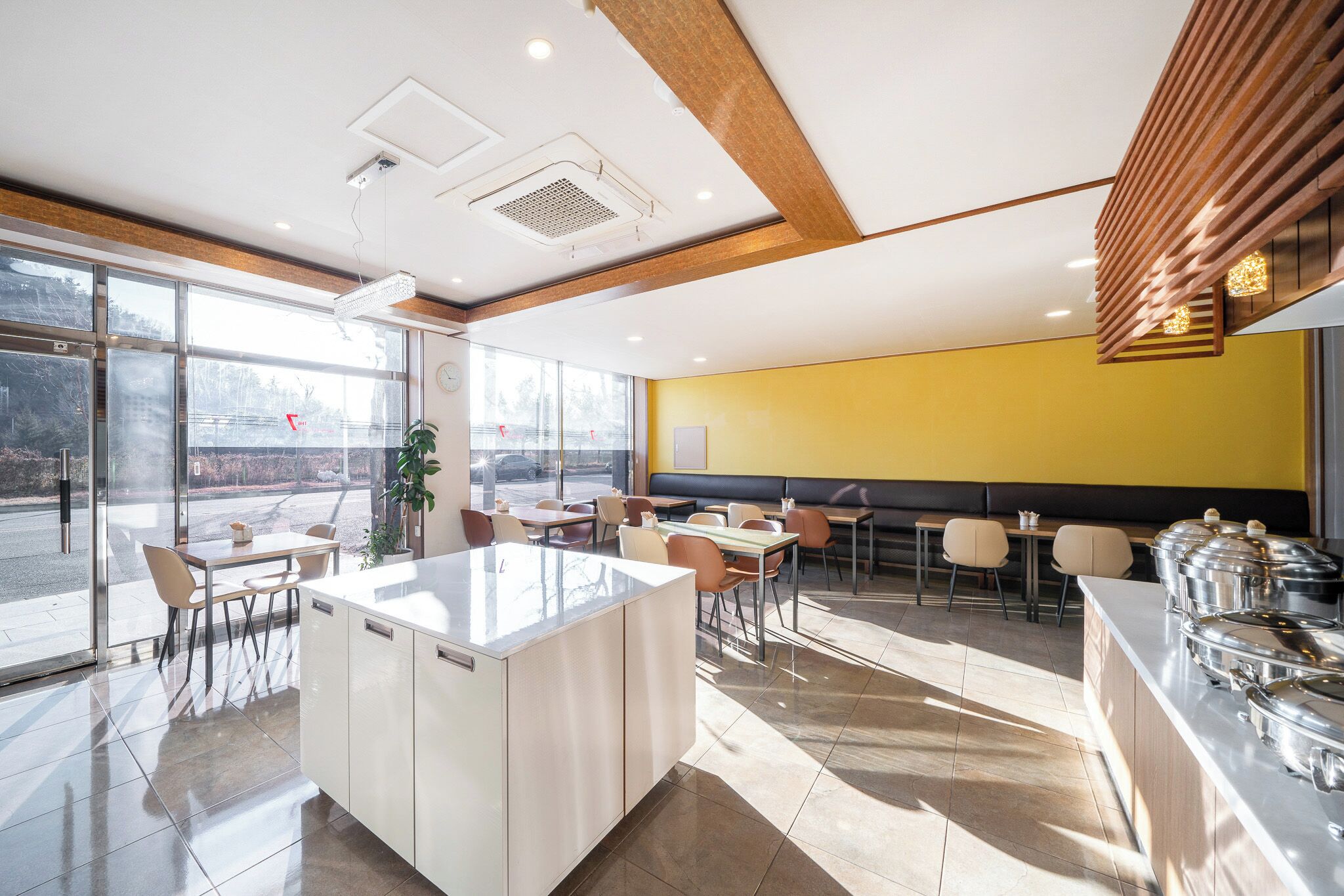 A modern restaurant with a central island, seating area, and a buffet counter.