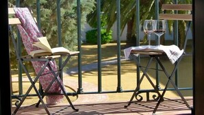 Un balcon avec une chaise et une petite table, toutes deux recouvertes d’une nappe.