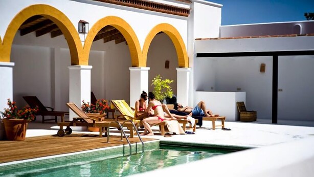 Un espace aménagé au bord de la piscine, avec des chaises longues et une piscine.