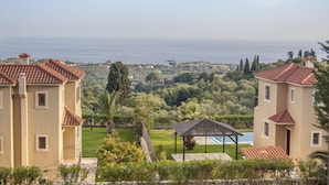 A coastal property with multiple buildings, a pool, and a view of the sea.