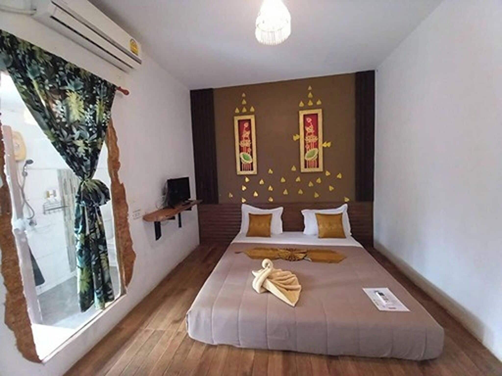 A bedroom with a bed, a window with curtains, a wall-mounted air conditioner, and a staircase.