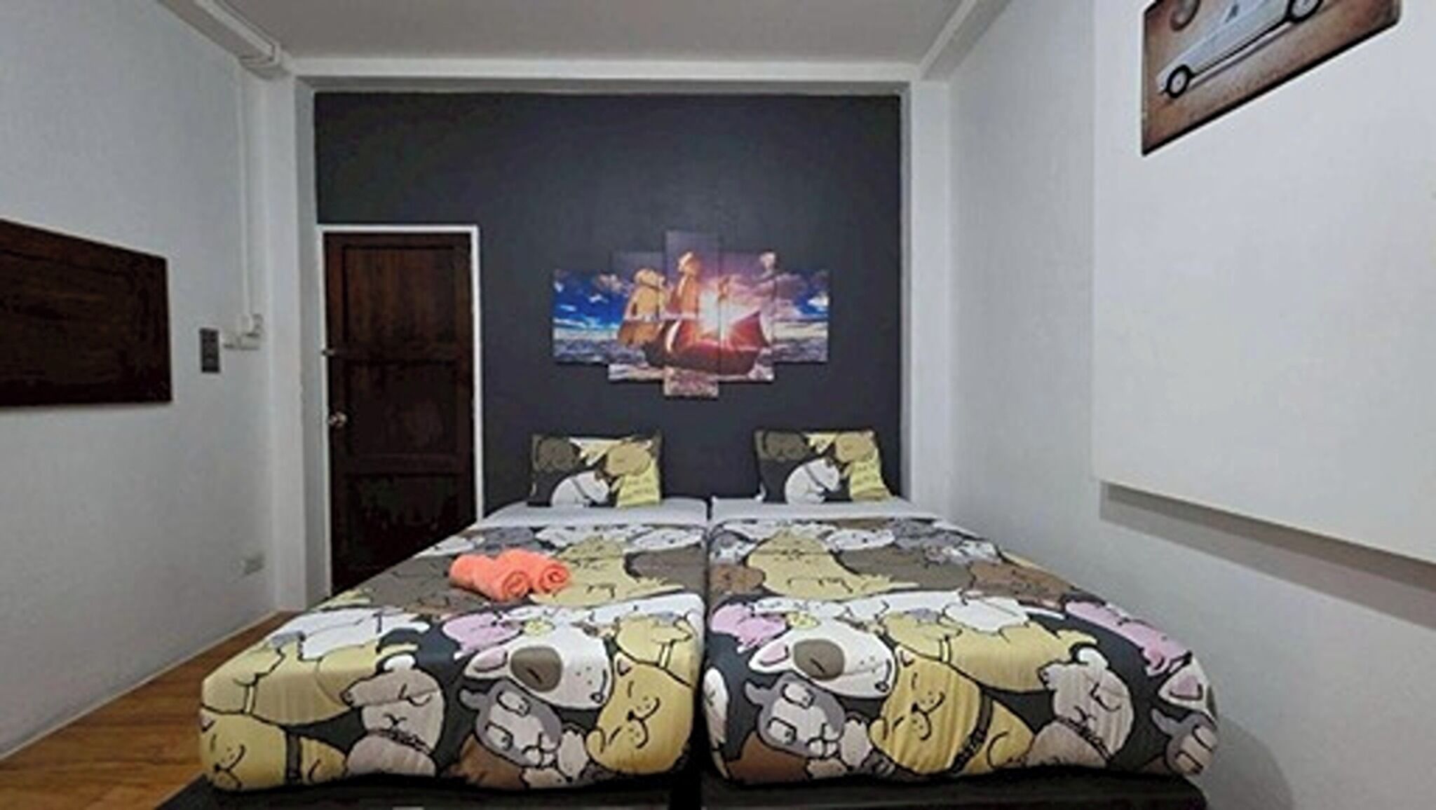 A bedroom with a bed, a door, and a wall with a painting.