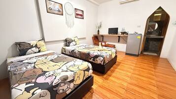 Una habitación con dos camas, un escritorio, un refrigerador y un espejo.