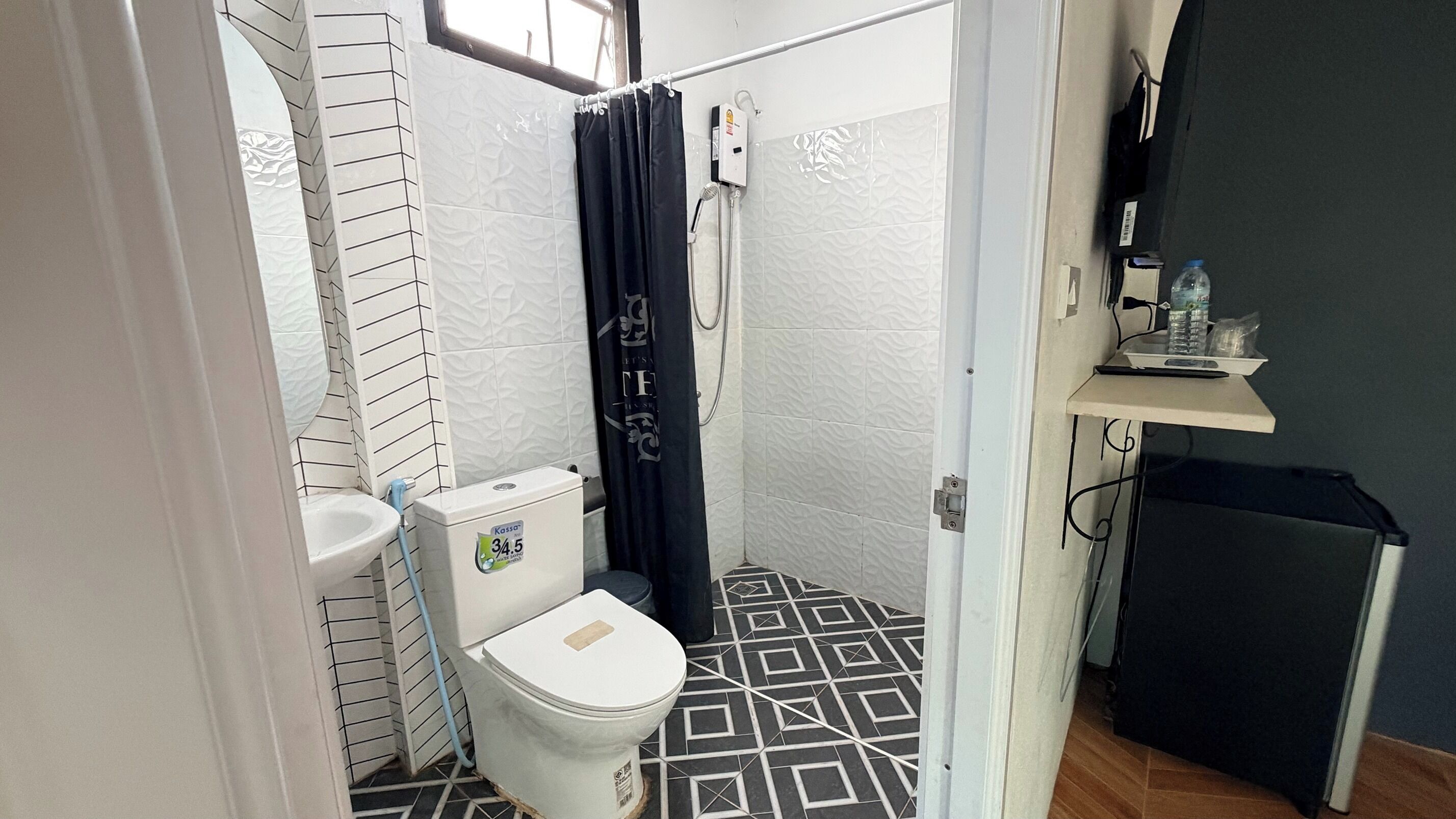 A compact bathroom with a toilet, a shower, and a sink.