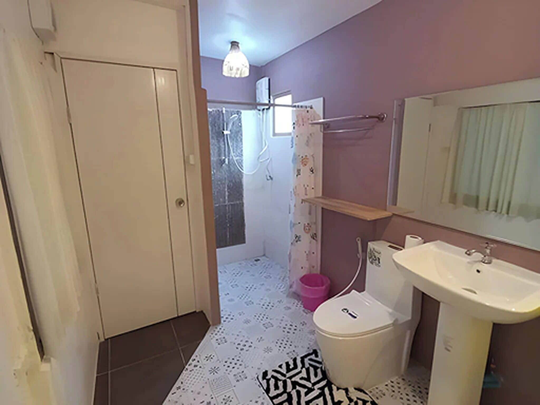 A bathroom with a toilet, sink, and shower area.