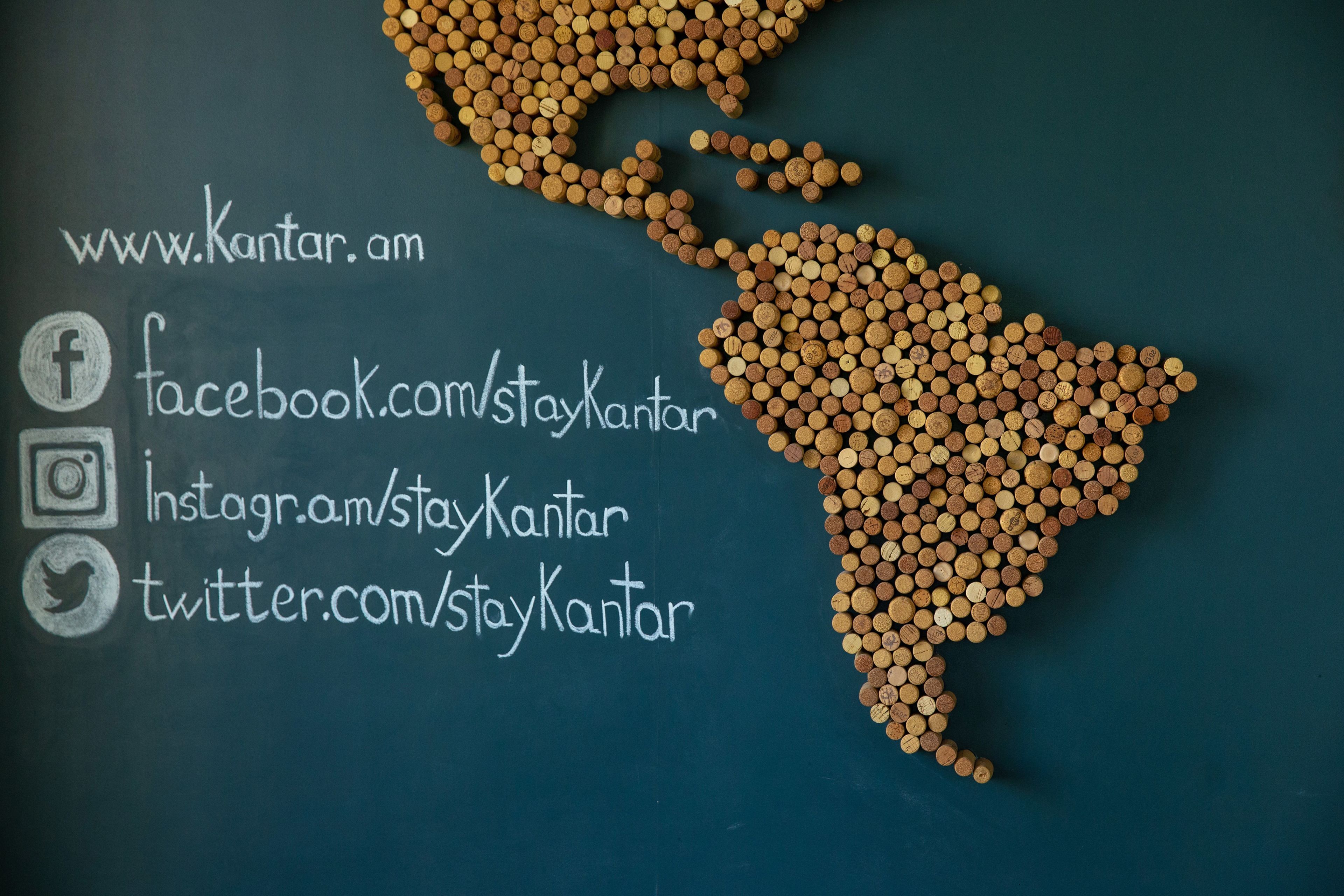 A map of South America made of wine corks with social media handles listed below.