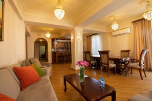 Leilighet, 2 soverom, balkong | Oppholdsområde | En 32-tommers LED-TV med Parabol-TV samt TV og bøker