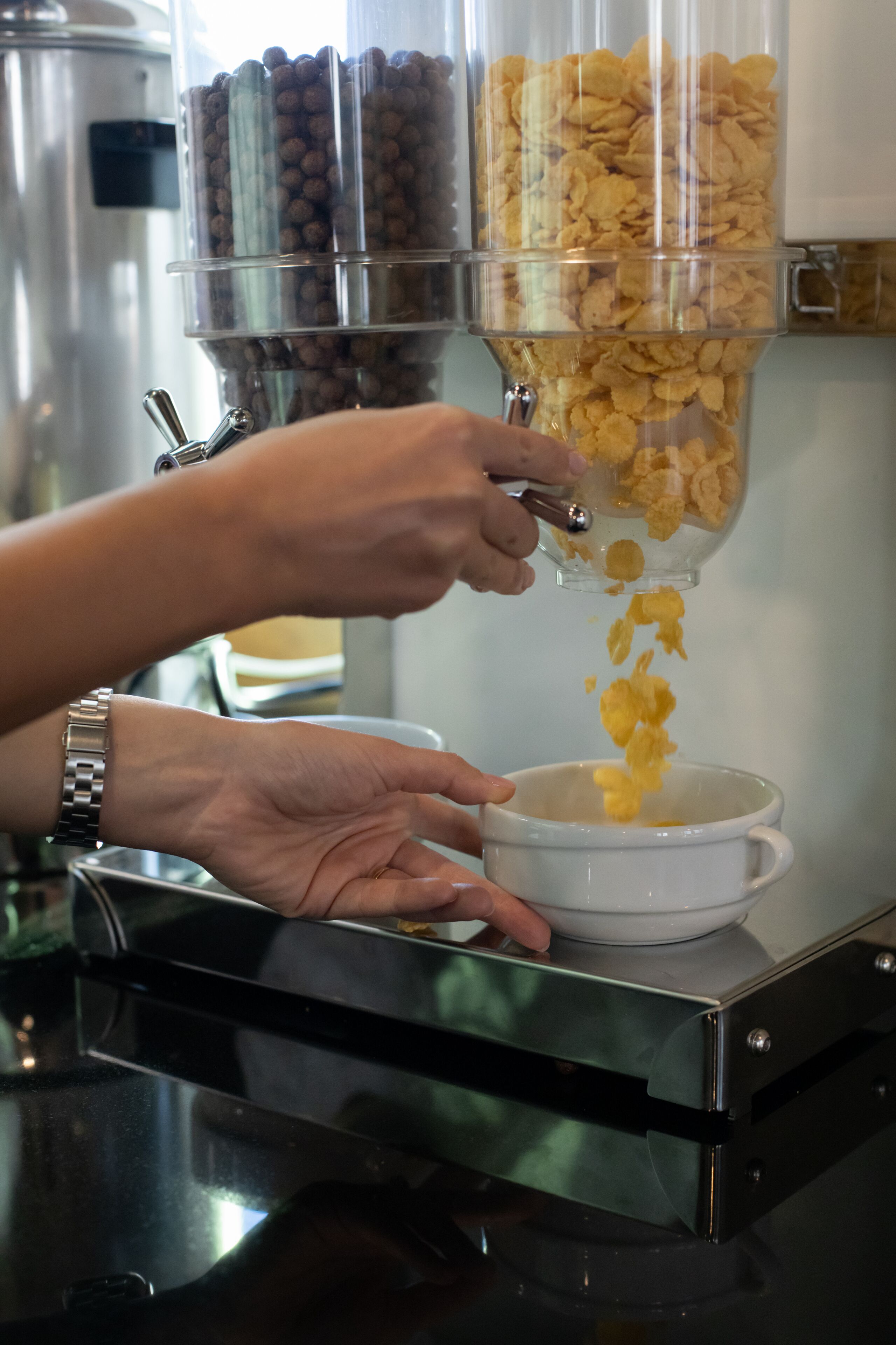 Una persona sirviendo cereal en un tazón.