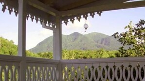 A covered outdoor area with a view of green mountains. - Fire Fly Cottage (Westbury)