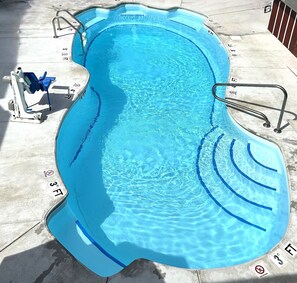 Piscine extérieure en saison, chaises longues