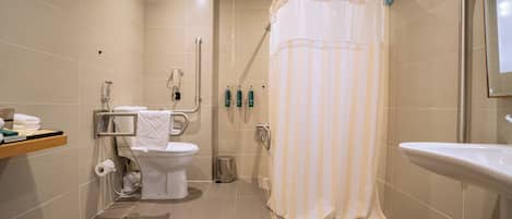 A modern bathroom with a shower, toilet, and sink.