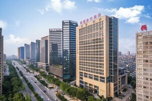 Un moderno edificio de gran altura con varios pisos, ventanas amplias y un letrero destacado en la parte superior.