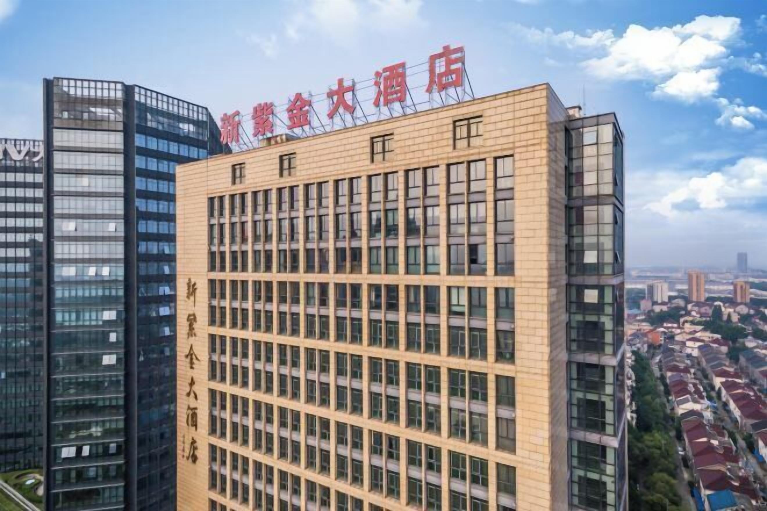 A modern hotel building with a prominent sign in Chinese characters.